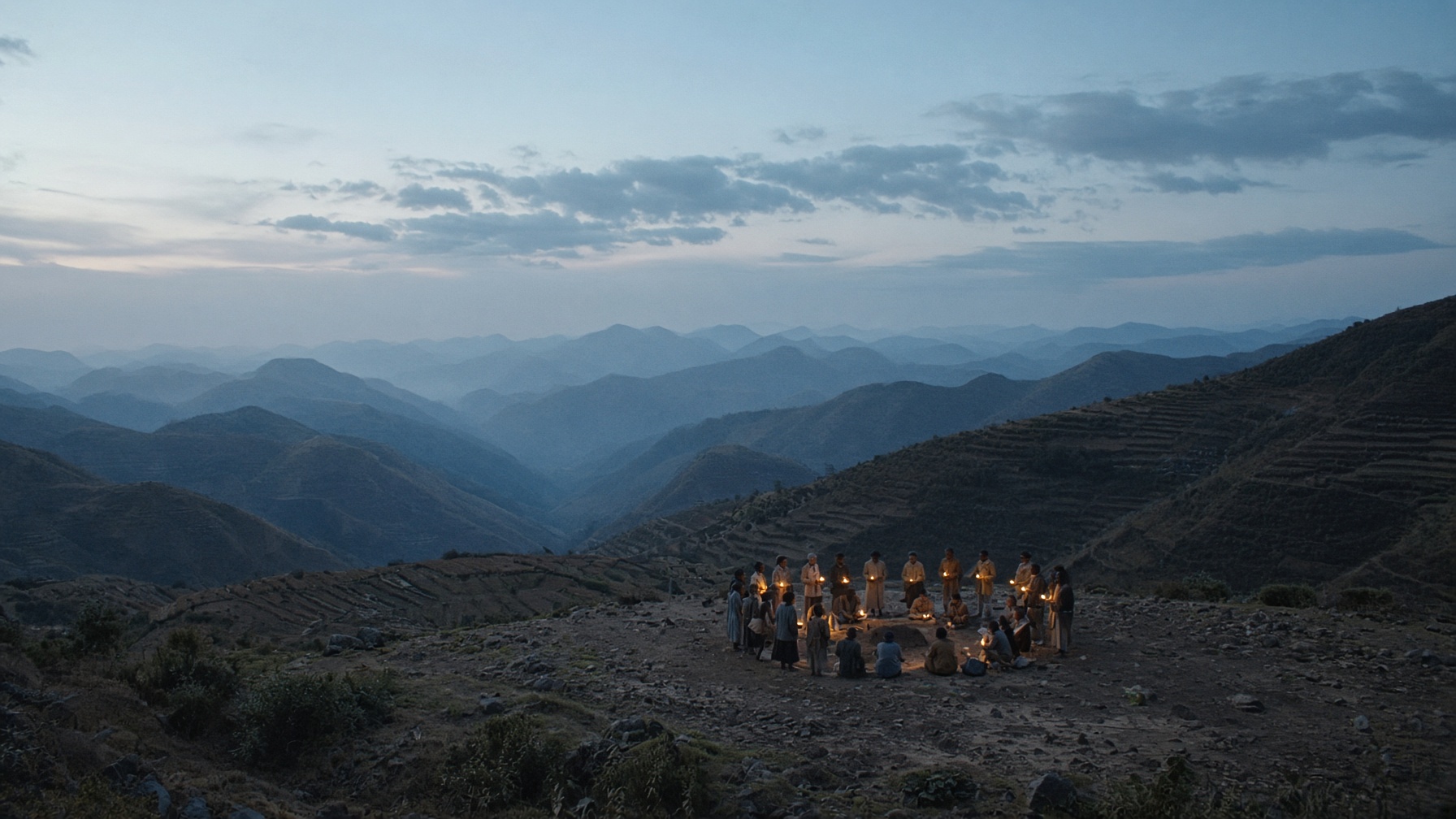 A village gathered by lamplight